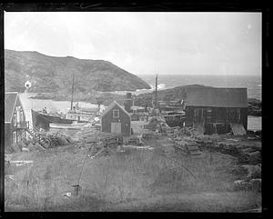 Unidentified docked boats by a pier with lobster traps in the foreground