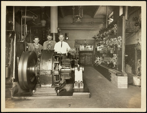 Men standing in room with machinery on Long Island in Boston Harbor