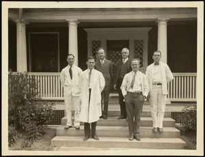 Portrait of men, possibly doctors or other medical personnel, standing in front of building on Long Island in Boston Harbor