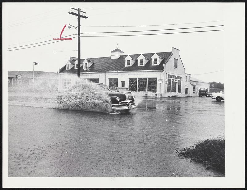 Car driving through flooded street