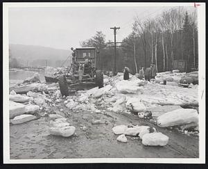 Icy Highway, only in this case the ice is in forms of huge cakes that flood water deposited on Route 120 in South Rumford, Me. A highway grader shoves the ice to the side of the road. Some of the cakes were three feet thick and weighed hundred of pounds.