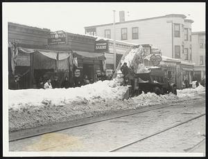 Reducing Snowpiles on Bowdoin street, Dorchester. Modern snow conveyor quickly loads waiting truck.