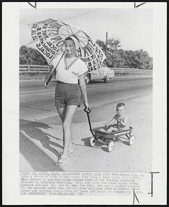 Riding Picket Line With Mom-- Jimmy Gau, 2, gets two-hour ride in his wagon four days a week while his mother, Mrs. Edward C. Gau Jr. walks picket duty at the Holiday Drive-In Theater is suburban Overland. Mrs. Gau said she takes Jimmy along because she has no one to care for him. She was a ticket cashier at the theater until she and 13 other empolyes went on strike three weeks ago seeking recognition of their AFL union as bargaining agent.