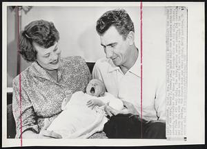 Such A Boring Business!--At the tender age of six days, Henry J. Sauer, Jr., holds still for a picture with his parents, Outfielder Hank Sauer of the Chicago Cubs and his wife, Esther, and finds it all very dull. The baby, weighing seven pounds, 14 1/2 ounces, was born the same day Hank was named the most valuable player in the National League. The Sauers have one other child, Betty Lorraine, 14 months old.