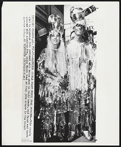 Aluminum Couple Enjoy Mardi Gras Parades--This couple clad in aluminum foil costumes with sauce pans on their heads, and faces and hands covered with aluminum ore, enjoy Mardi Gras as they join others in the street parades today.
