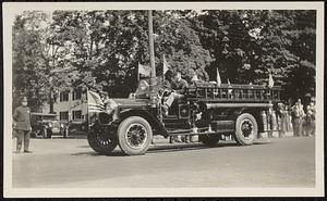 Photograph of a Sharon parade with a fire truck in the foreground and a policeman on the left