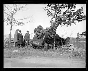 Overturned car next to a tree