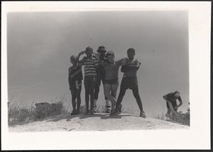 Five boys, including Seamus, Jamyel and Philip, standing and posing at the beach