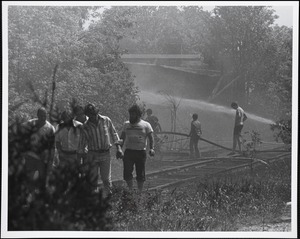 Looking towards Locke Lumber Yard from railroad tracks just behind branch and Kingsbury Block on Great Plain Avenue, during Needham Square fire of May 22, 1977