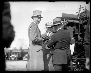 Three unidentified men standing next to a stagecoach