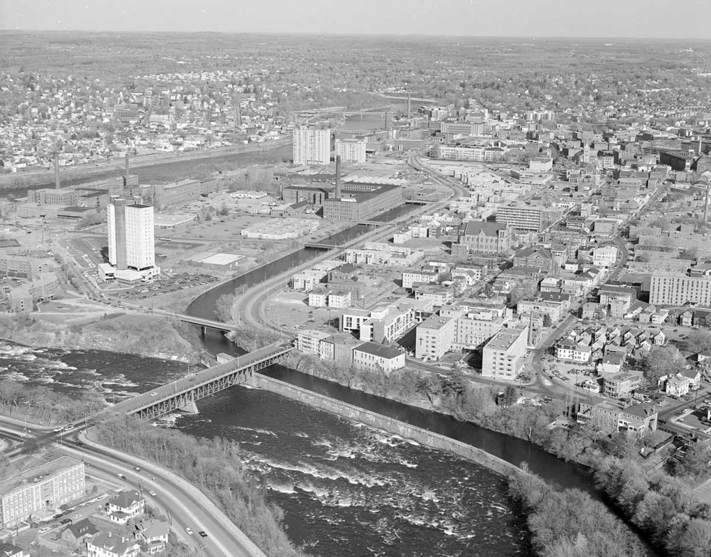 Looking across Pawtucket Dam and Northern Canal at Textile (University Ave.) Bridge to big view of Lowell