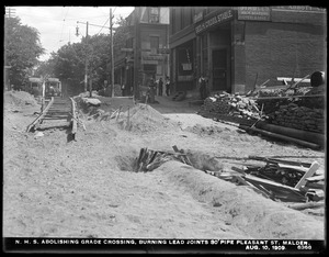 Distribution Department, Northern High Service Pipe Lines, abolishing grade crossing, burning lead joints in 30-inch pipe, Pleasant Street, Malden, Mass., Aug. 10, 1909