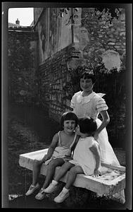 Three girls posed on a bench