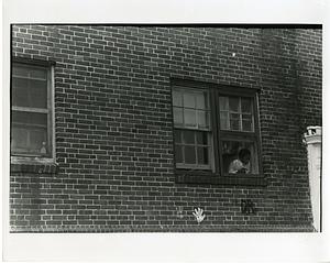 Young boy looking out a window