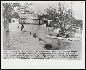 Leave Isolated Farm-- Ted Morgan and B. Pitts row away from the floodwater-isolated Morgan farm about eight miles west of here yesterday. The two men rowed out to a waiting Army duck which took them to safety. The men had remained to care for the place.