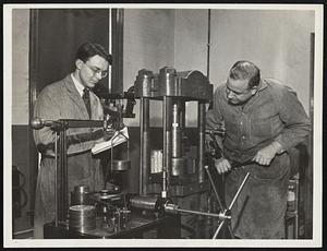 Develop High Pressure Device. Robert Williams (left), assistant, and Dr. Thomas Poulter, director of the Research Foundation of the Armour Institute of Technology, demonstrate the new device they have developed for producing the record pressure of 1,500,000 pounds per square inch. This pressure, exceeding anything heretofore attained, will open up many new fields of research.