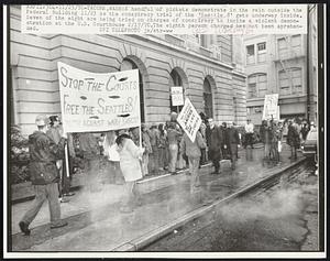 A handful of pickets demonstrate in the rain outside the Federal Building 11/23 as the conspiracy trial of the 'Seattle 8' gets underway inside. Seven of the eight are being tried on charges of conspiracy to incite a violent demonstration at the U.S. Courthouse 2/17/70. The eighth person charged has not been apprehended.