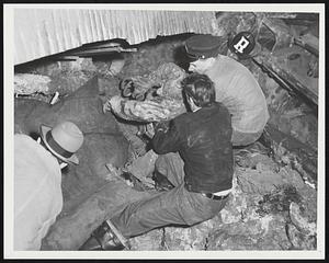 Man being removed from hole beneath the steam shovel at clay pit