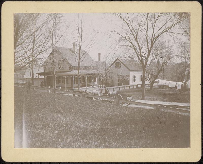 Cape-style house with horse and wagon in front and laundry on line