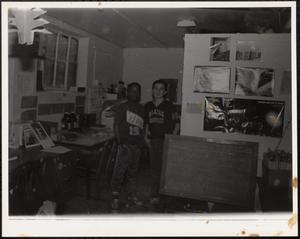 Two boys in a basement in sports t-shirts