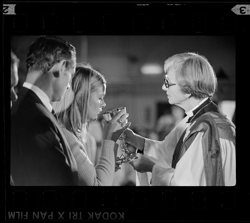 Priest offers sacramental wine to parishoner