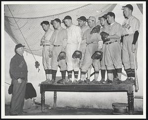 Baseball players standing on table, looking down at an older man