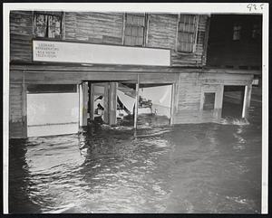 Flood Damage- this electrical appliance shop on Foster St., Peabody, was one of the many buildings flooded when a dam break covered two square miles in the heart of the city with tons of water.