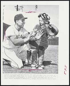 Phoenix, Ariz. – “That’s The Way” – Catcher Cuno Barragan of the Chicago Cubs takes time out from a spring training session to show his 6-year-old son, Steve, how to catch a fast ball. The Cubs started their spring training at Mesa, Ariz., today.