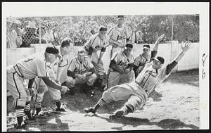 Gas House Style- St. Louis Cardinal Catcher Joe Garagiola flings arms in tradition of old Gas House Gang as he demonstrates sliding in the pit at Al Lang Field in St. Petersburg. Fla., where Cards are training. Coaches Ray Blades (left) and Terry Moore (second from left) with Garagiola's help are tutoring the group of rookies looking on.