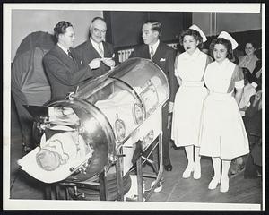 Charity Begins At Home, it was decided this year by the Cambridge committee for the President's Birthday Ball. Therefoe, instead of sending the proceeds to the national committee in New York, the committee bought this iron lung last night presented it to Cambridge City Hospital. Left to right: John J. Carver, chairman of the hospital trustees; Acting Mayor Francis L. Sennett; Daniel J. O'Brien, Birthday ball chairman, and Nurses Anne Smith and Angeline Silvestri.