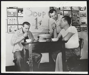 Soup for Strikers -- Restaurant proprietor Charles DeBracy watches as two striking steelworkers eat the one-cent bowls of soup he has promised to provide strikers in Lorain, O., until the dispute is settled. DeBracy and his partner, Frank Ursic (not in picture), explained, "Men need to keep warm on the picket line." Edward Bayus (left) and Michael Byar are both employed by the National Tube Co. in Lorain