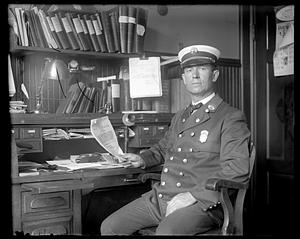 Firefighter officer (battalion chief) seated at a desk