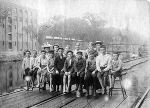 Children seated on North Canal island in front of the Pacific Mills around noon, ca.1896