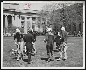 Referee Frederick G. Fassett Jr. (man in the soft hat) attempts to admonish players after a particular play. Most of the players, incidentally, are on the staff of the campus humor magazine "Voodoo".