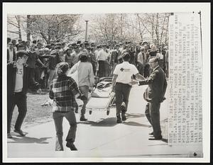 Hit By Gunfire in Campus Riot. A stretcher is rushed in to carry away a student hit by gunfire today in the fourth day of rioting by students of Kent State University in Northeast Ohio. Four persons were killed and at least 11 wounded as National Guardsmen attempted to halt the rioting students.
