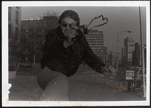 Young man jumping with a camera in his hand