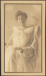 Isabel in loose white dress, seated