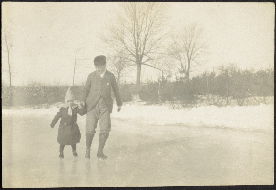Man in fur hat and small girl skating on frozen lake near shore