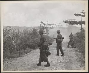 Pushing across Tinian Island, U. S. Marines wage a fight from cane field to cane field