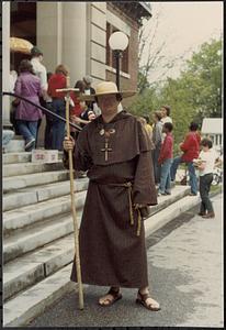 Man dressed as monk, steps Lawrence Library