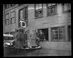 People in a boat in front of Megansett, Jr. T Wharf