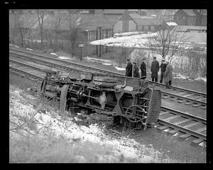 Wrecked Gulf truck overturned by the side of railroad tracks