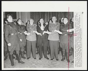 East-West Harmony - London's Lord Mayor, Cuthbert Ackroyd, center, joins hands with visiting Russian Red Army choir and dance group for signing of " Auld Lang Syne" at reception in British Capital's Mansion House Thursday. Russian group has attracted large audiences in London performances