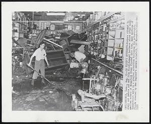 In Flood’s Aftermath-Workers attempt to clear out debris and mud from flood-damaged hardware store after rain-swollen waters of Naugatuck River flooded this town. Many sections of Connecticut were in a similar situation following the catastrophic floods created by New England’s severe rainfall.