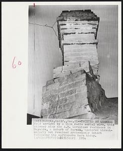 Twisted by Quake--Held upright by a thin radio aerial wire, this chimney atop the A.M. Lorentzen residence in Bayside, a suburb of Eureka, teetered threateningly but remained grotesquely intact following the earthquake here today.