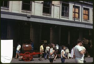 A man with a hand pulled cart outside of Quincy Market