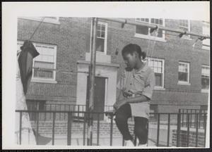 Young woman sitting on railing