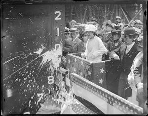 Sponsor breaks bottle of champagne on ships prow at launch from Fore River Ship Building Co., Quincy
