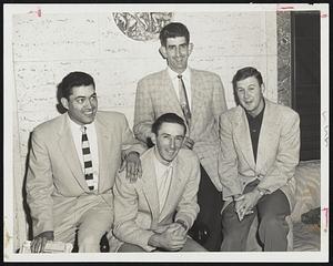 Cleveland's New Indians relax at their Hotel Kenmore headquarters after today's game with the Red Sox was postponed because of inclement weather. The newcomers to the tribe are, left to right, Third Baseman Rudy Regalado, Pitcher Ray Narleski, and Catcher Hal Naragon. Standing is Pitcher Don Mossi.