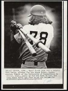 On Deck For a Trim? -- Curt Kelly, pitcher for the Avery Point, South-eastern Branch of the University of Connecticut in Groton, Conn., warms up for his turn at bat. His long curls spill out from under his helmet.